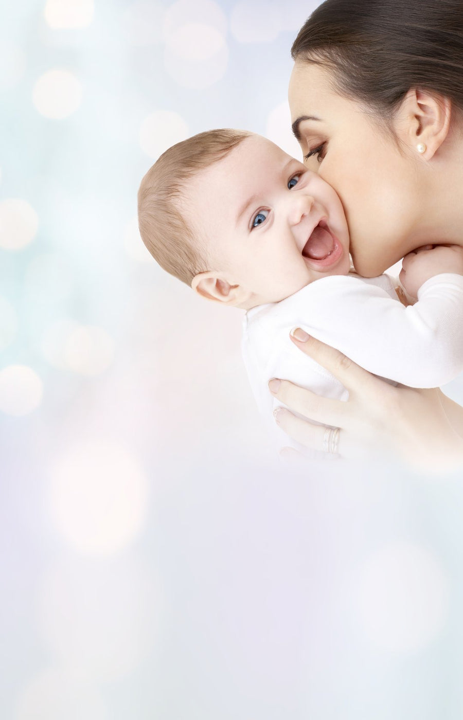 Mother kissing her laughing baby