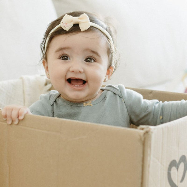 Smiling baby girl sitting – Stage 2 formula, 6–10 months